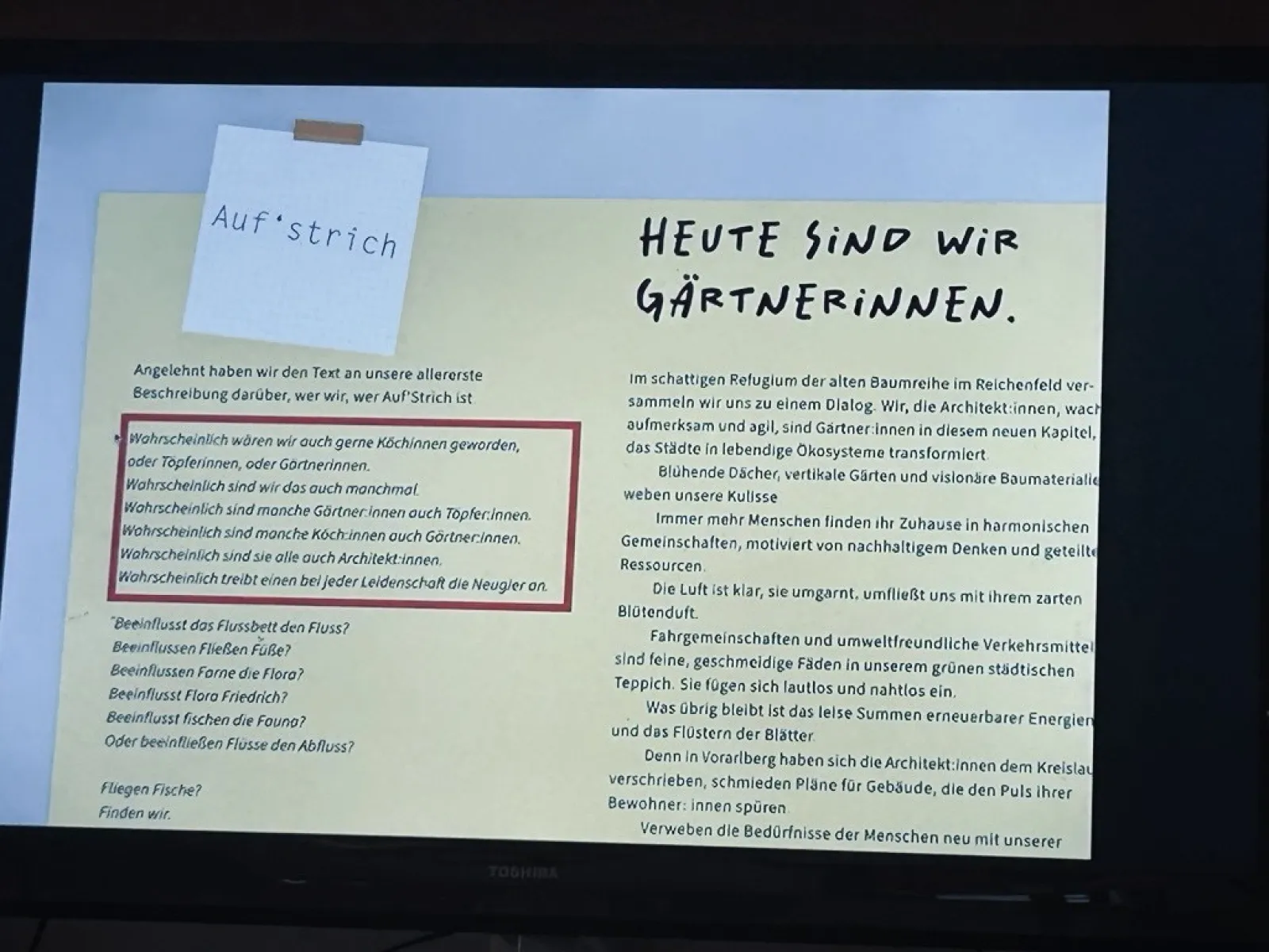 Ein Bildschirm zeigt eine Präsentationsfolie mit dem Titel "Heute sind wir Gärtnerinnen". Links oben ist ein Notizzettel mit der Aufschrift "Auf’strich" zu sehen. Der Text auf der Folie beschreibt kreative Ansätze in der Architektur und die Verbindung zur Natur.