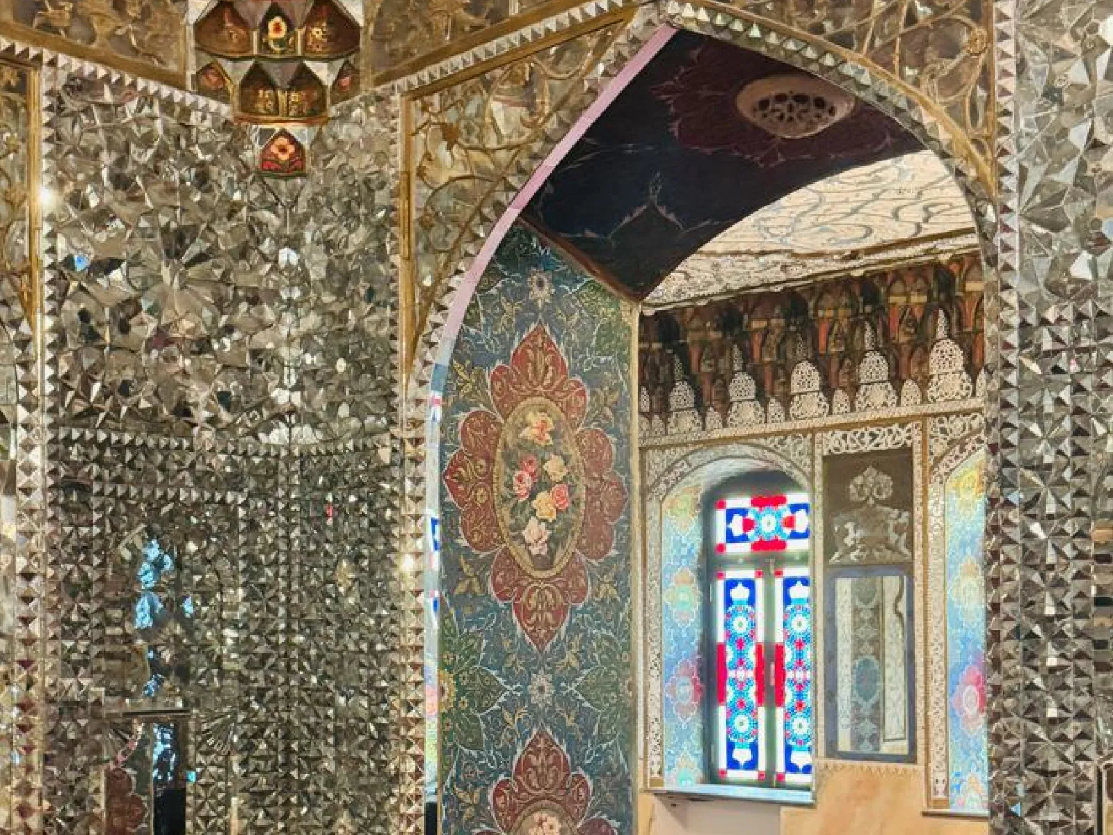 Prächtiger Innenraum mit reich verzierten Spiegelmosaiken und bunten Glasfenstern, die traditionelle georgische Architektur und Kunsthandwerk zeigen.