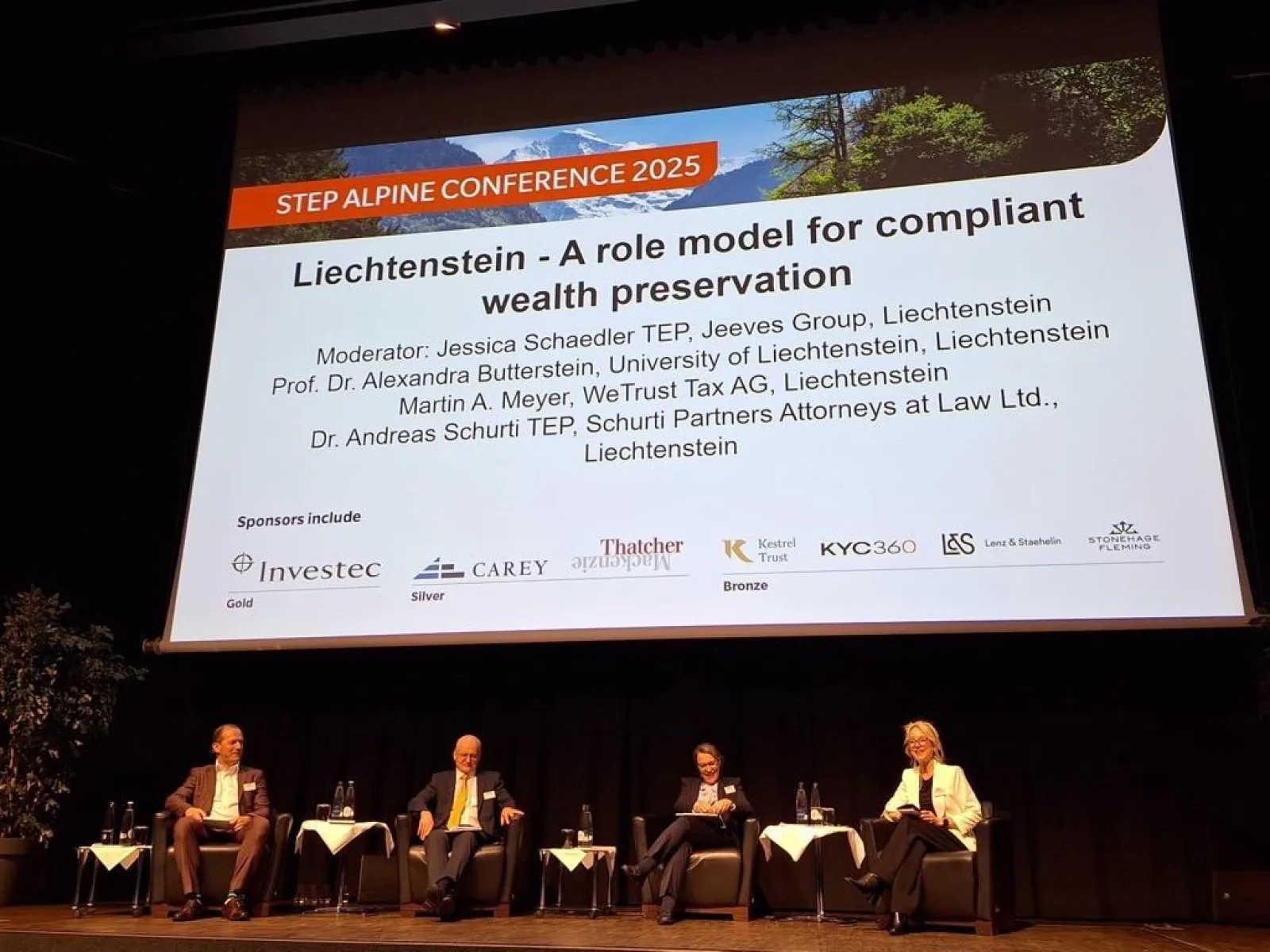 Podiumsdiskussion bei der STEP Alpine Conference 2025 mit vier Expertinnen und Experten auf einer Bühne vor einer großen Leinwand, die das Thema „Liechtenstein – A role model for compliant wealth preservation“ zeigt.