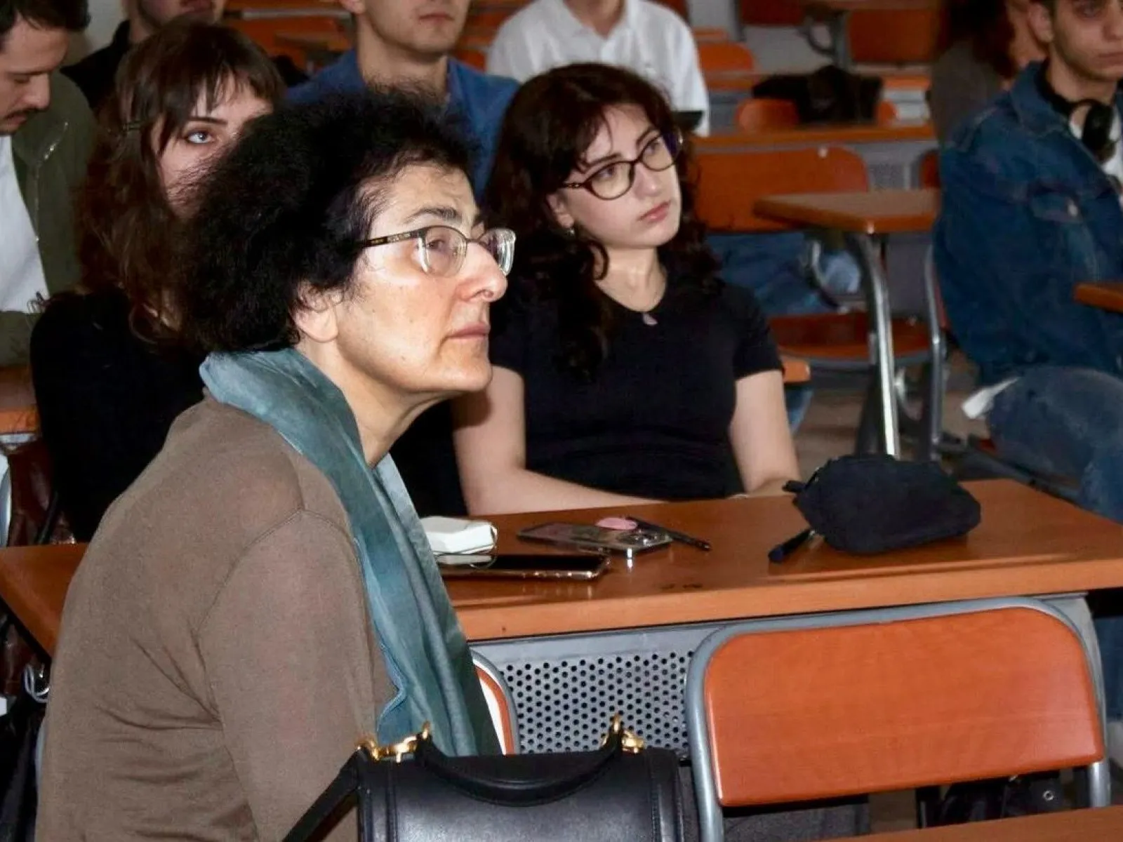 Studierende und Gäste verfolgen aufmerksam einen Vortrag.