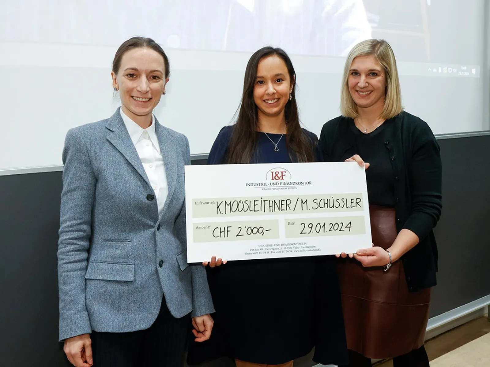 Drei Personen stehen nebeneinander und halten einen großen Scheck mit der Aufschrift "I&F Family Wealth Preservation Award". Die Summe von 2000 CHF und das Datum 29.01.2024 sind sichtbar. Sie lächeln in die Kamera.