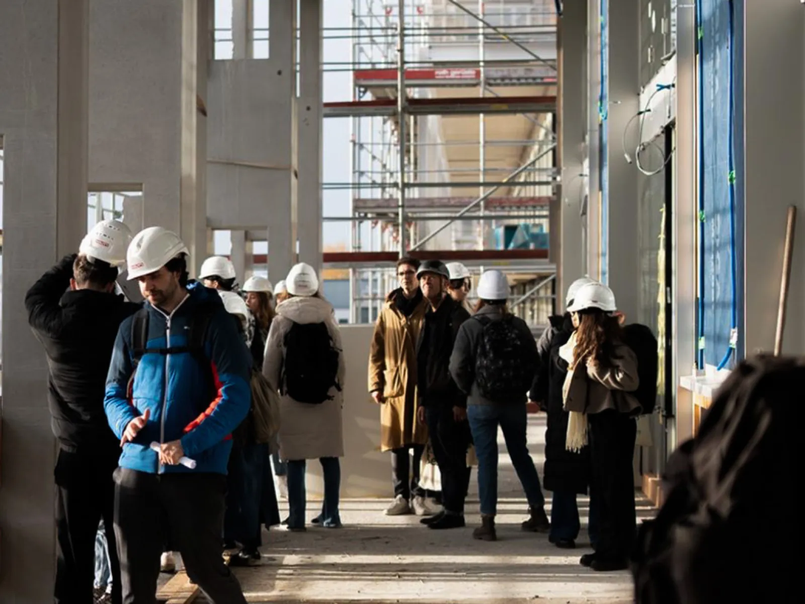 Mehrere junge Menschen mit Baustellenhelm