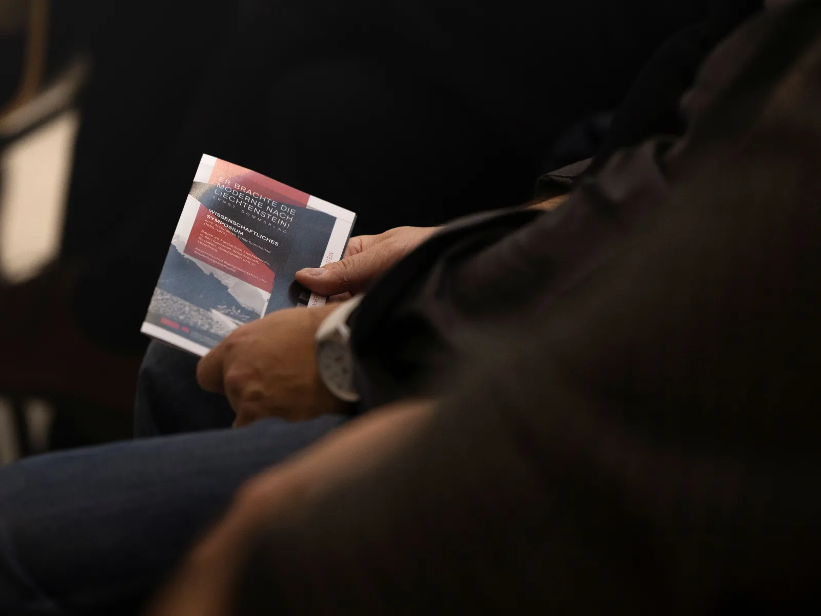 Nahaufnahme eines Vortragsflyers in rot und schwarz 