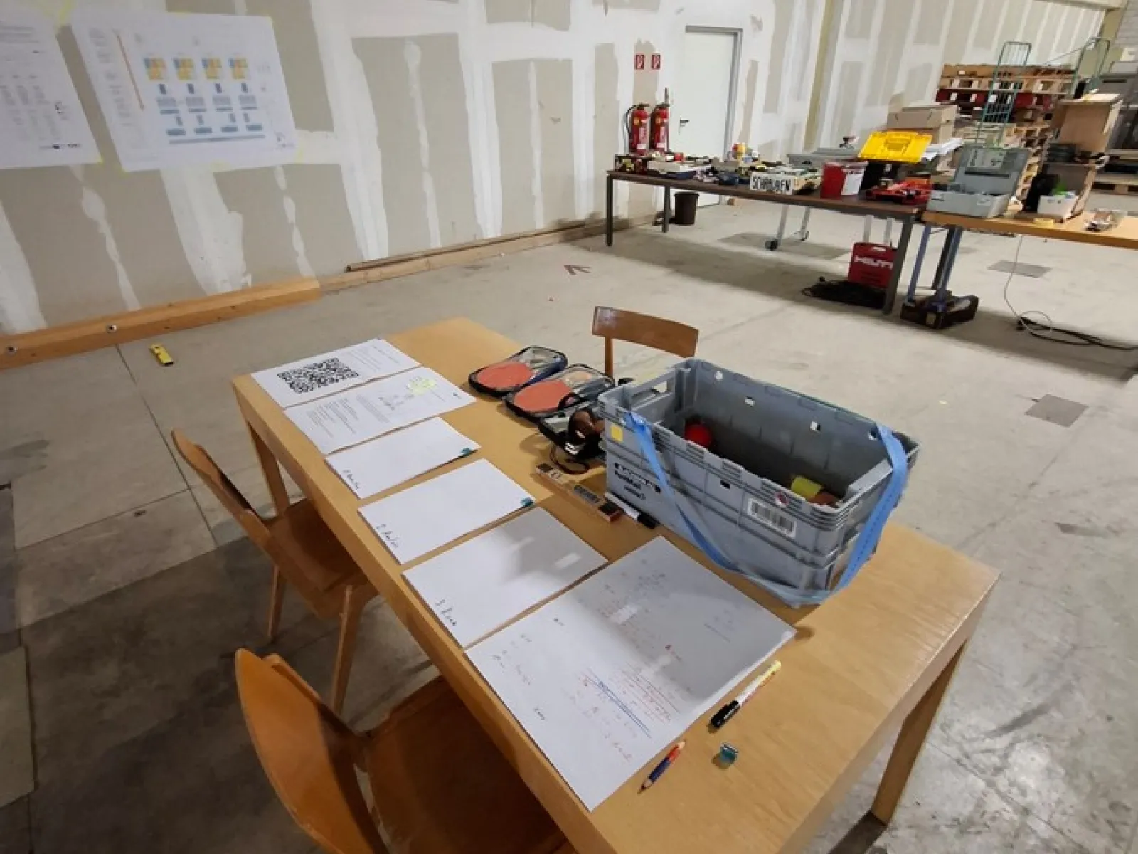 Ein Holzstuhl und Holztisch in einer grossen Halle 