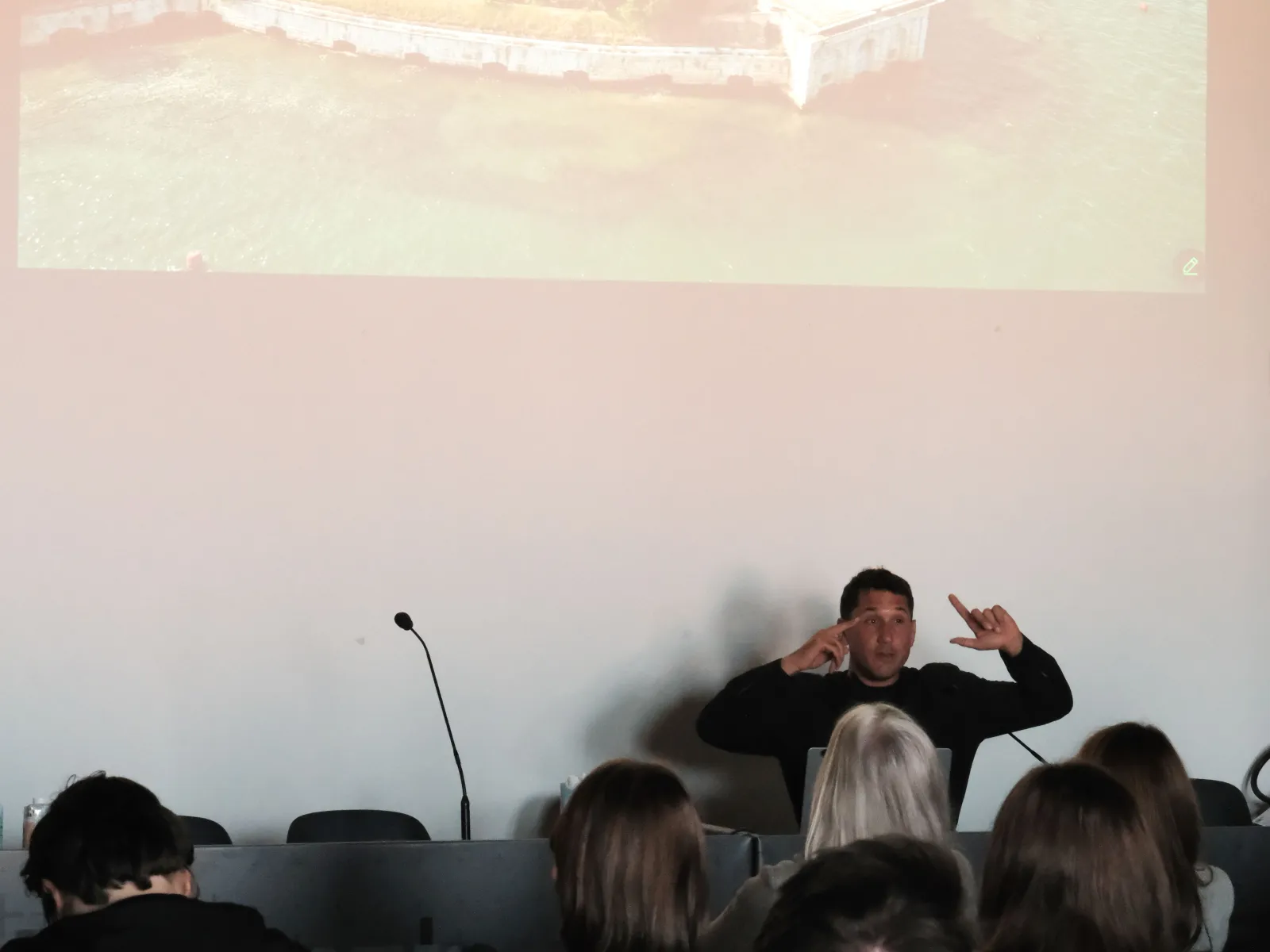 Mann präsentiert vor einer Leinwand