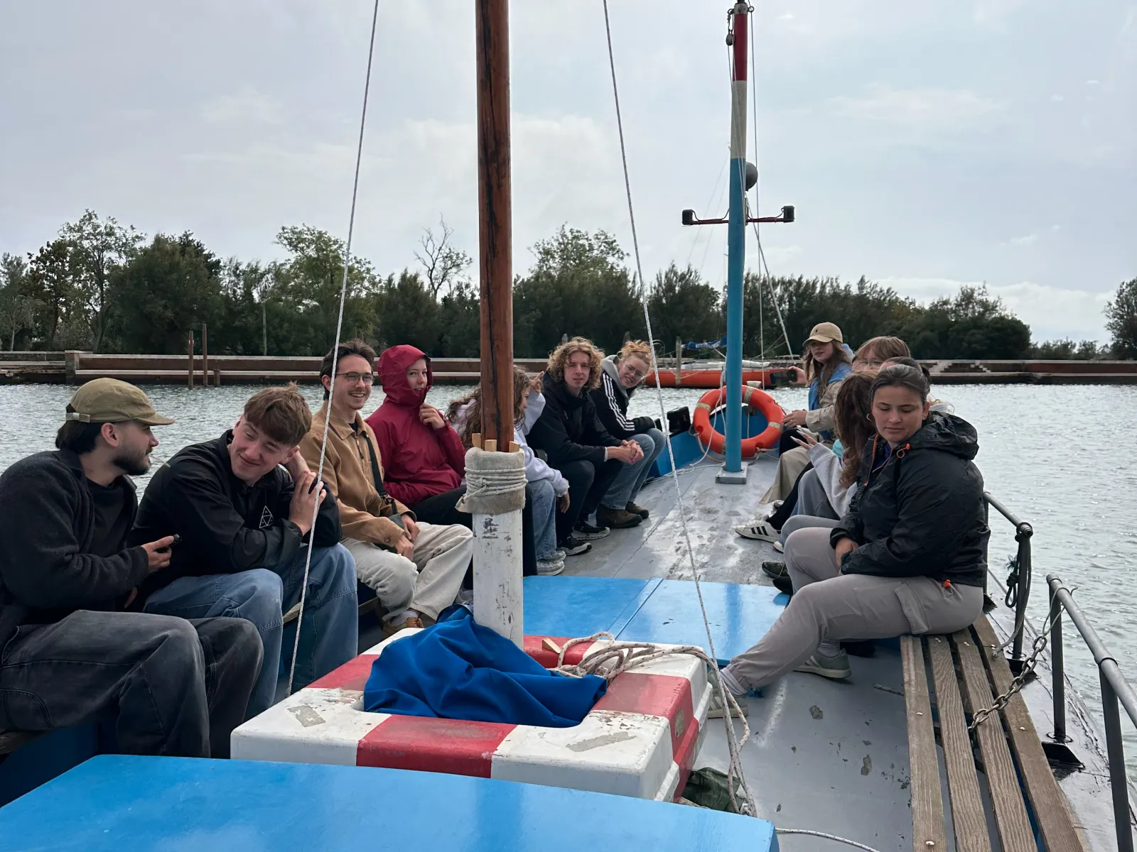 Mehrere junge Menschen sitzen auf einem Segelboot