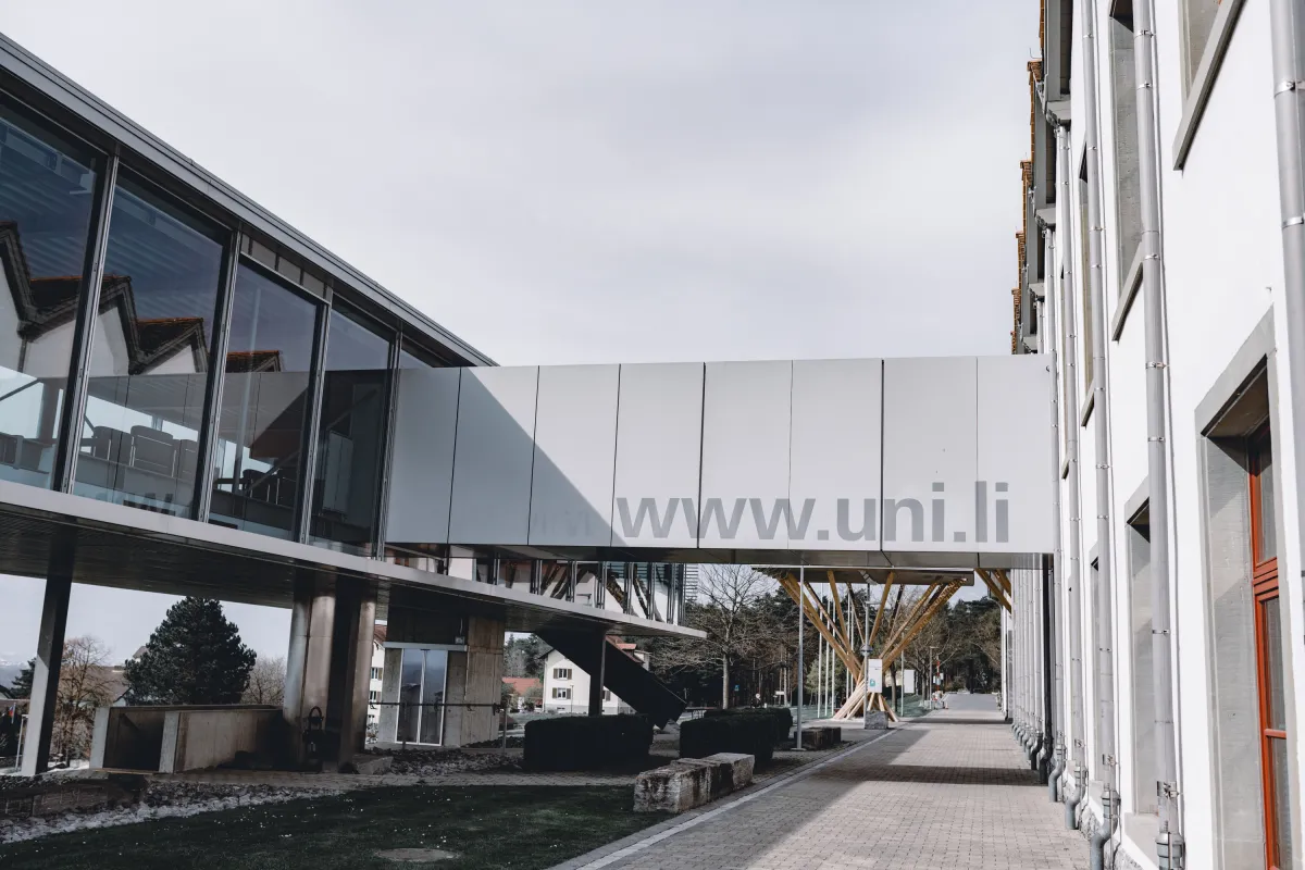 Seitenansicht des Verbindungsgangs mit www.uni.li Adresse zwischen den Gebäuden der Universität Liechtenstein.