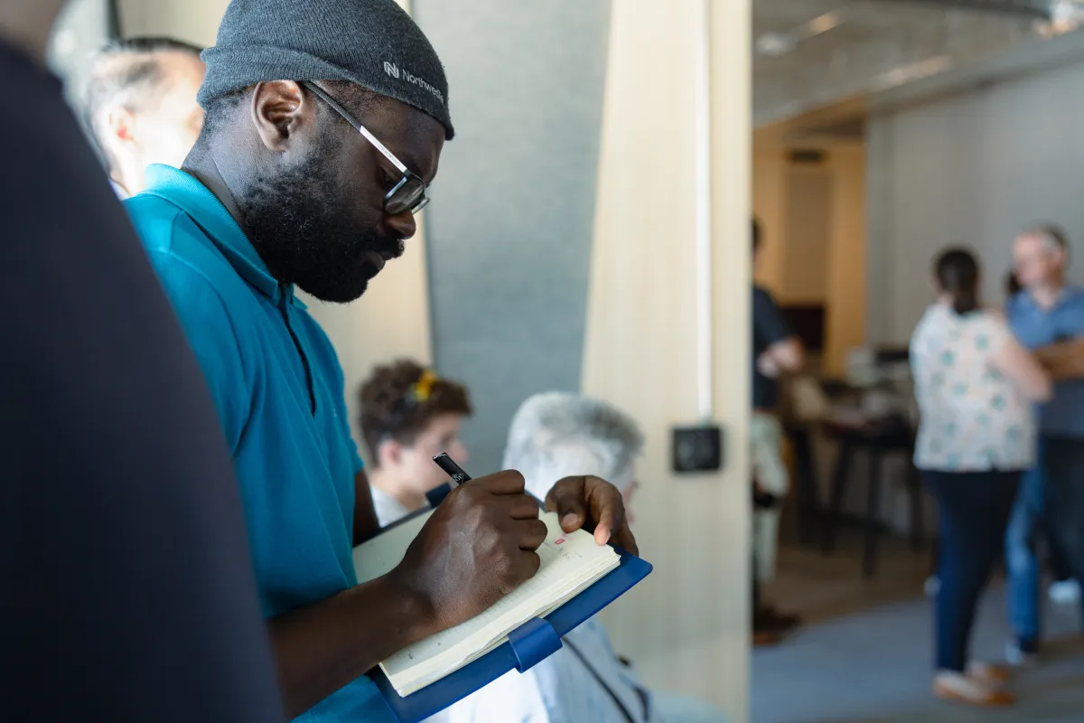 Teilnehmer schreibt in Notizbuch bei Weiterbildung an der Universität Liechtenstein.