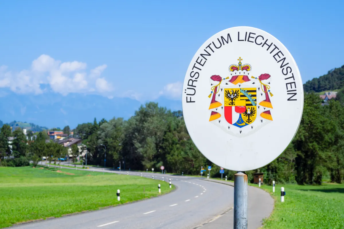 Grenzschild Fuerstentum Liechtenstein Strasse in grüner Umgebung