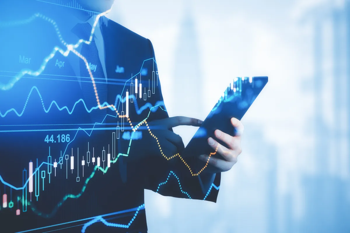 Person in Businesskleidung analysiert Finanzdiagramme auf Tablet.