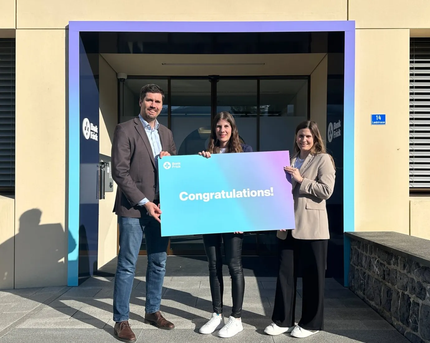 Sabrina Zimmermann, die Stipendiatin von Bank Frick, steht vor dem Gebäude der Bank Frick, bereit, am CAS Blockchain und Fintech Programm teilzunehmen.