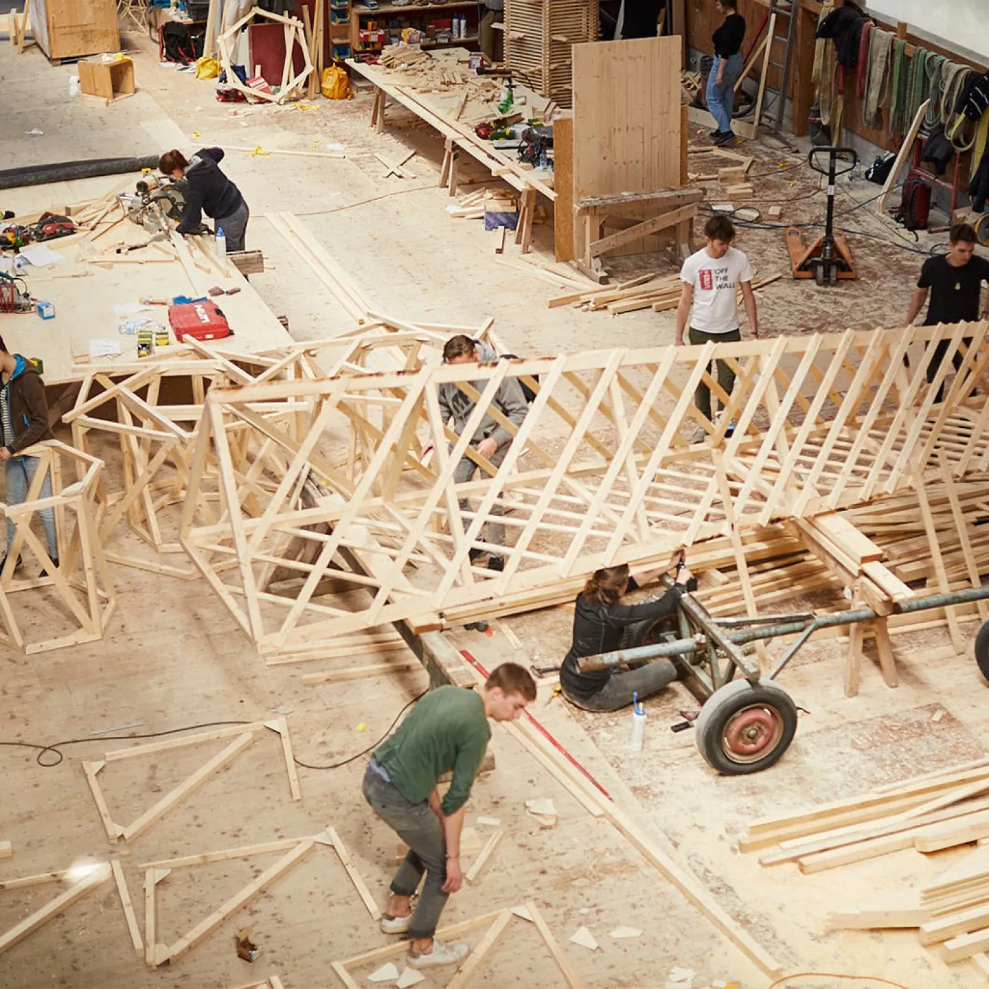 Eine Holzwerkstatt wo ein Turm aus Holz von Menschen gebaut wird