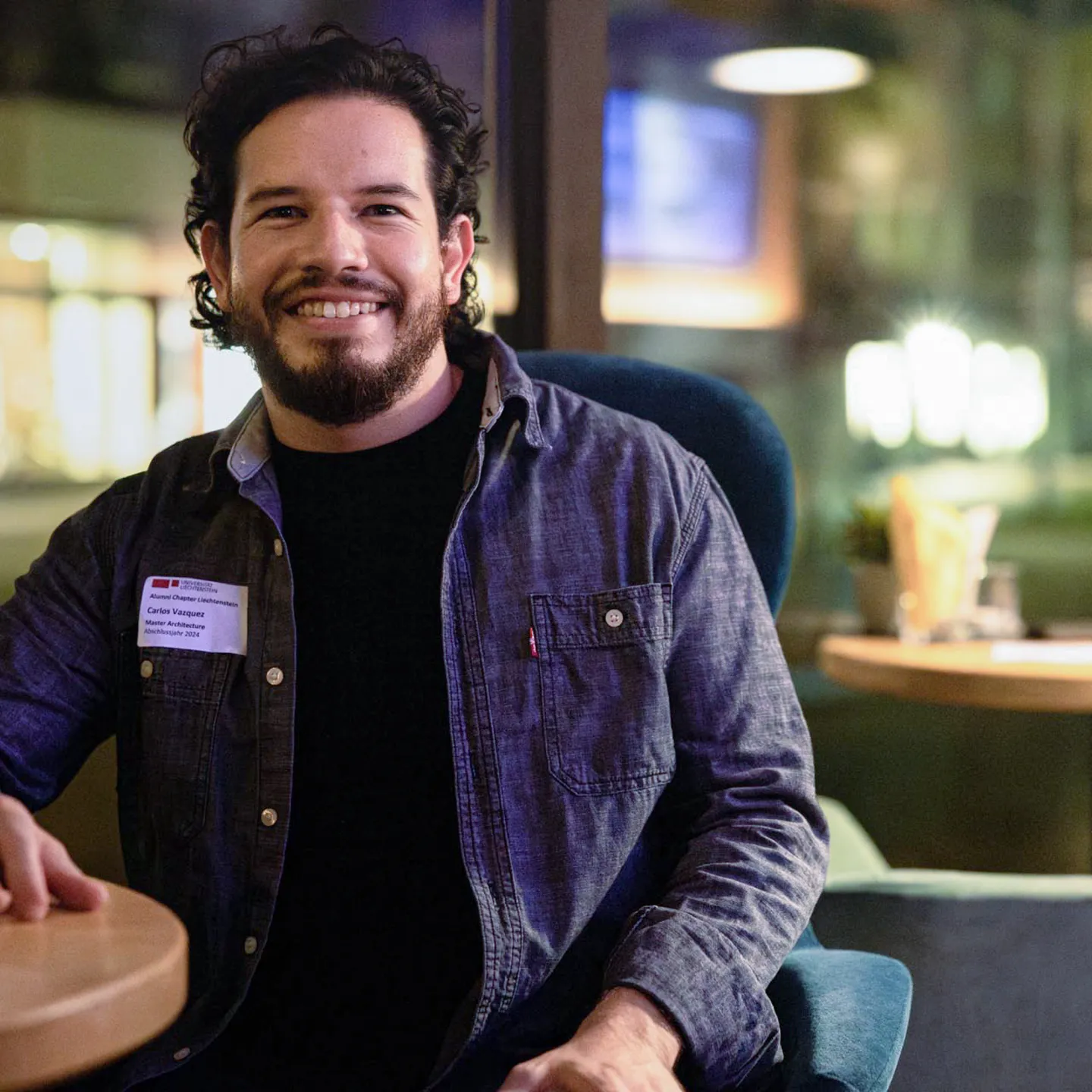 Lachender Teilnehmer des Alumni Treffens der Universität Liechtenstein in entspannter Abendatmosphäre