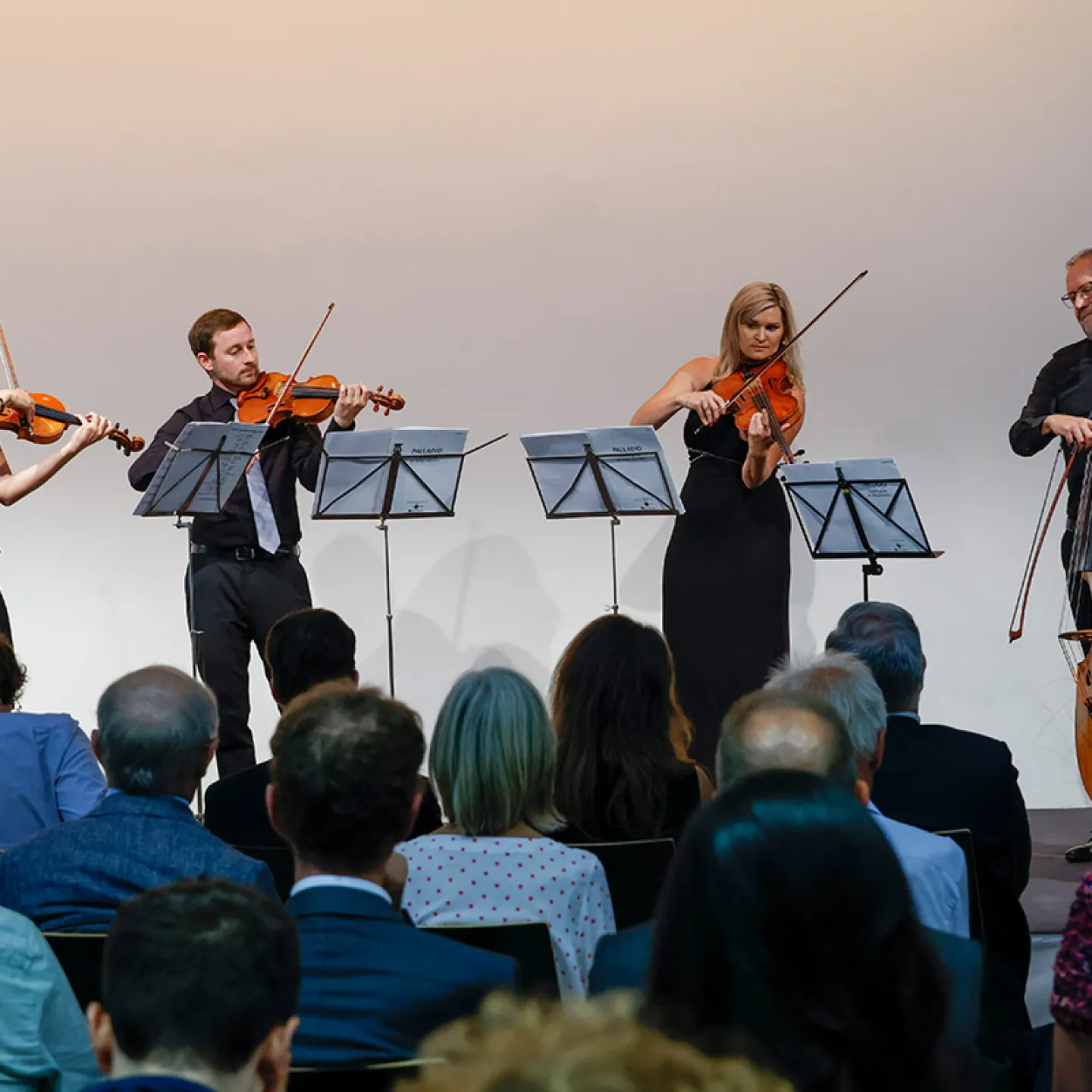 Streichquartett mit Kontrabass spielt vor Publikum auf einer Buehne im Rahmen einer feierlichen Veranstaltung.