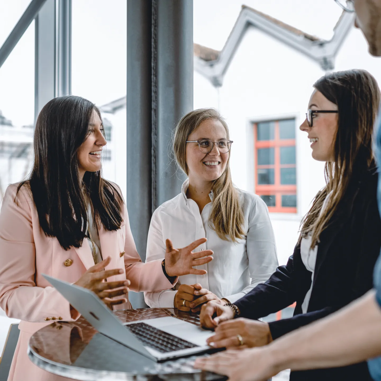 Eine Gruppe Studierende stehen im Gebäude der Universität Liechtenstein um einen Tisch