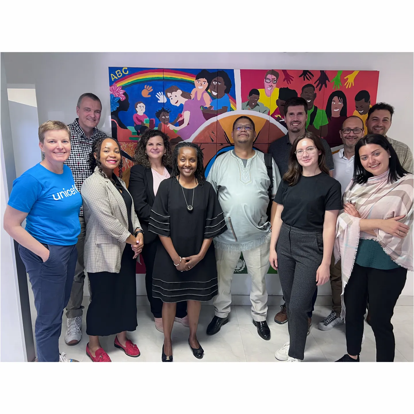 Gruppe internationaler Partnerinnen und Partner des Projekts Innovative and Digital Finance an der Universität Liechtenstein vor einem bunten Wandbild.