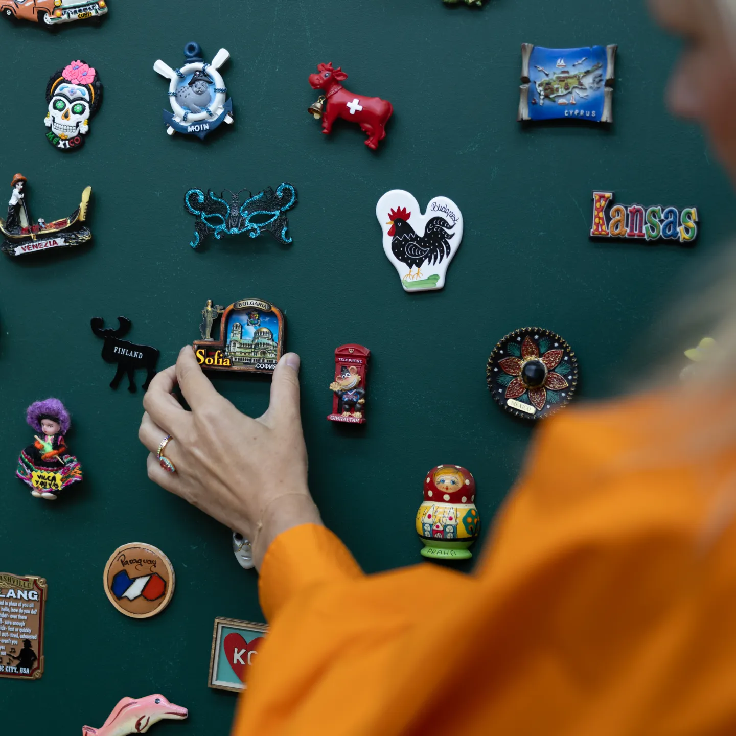 Hand platziert Souvenir-Magnet aus Sofia an Magnetwand.