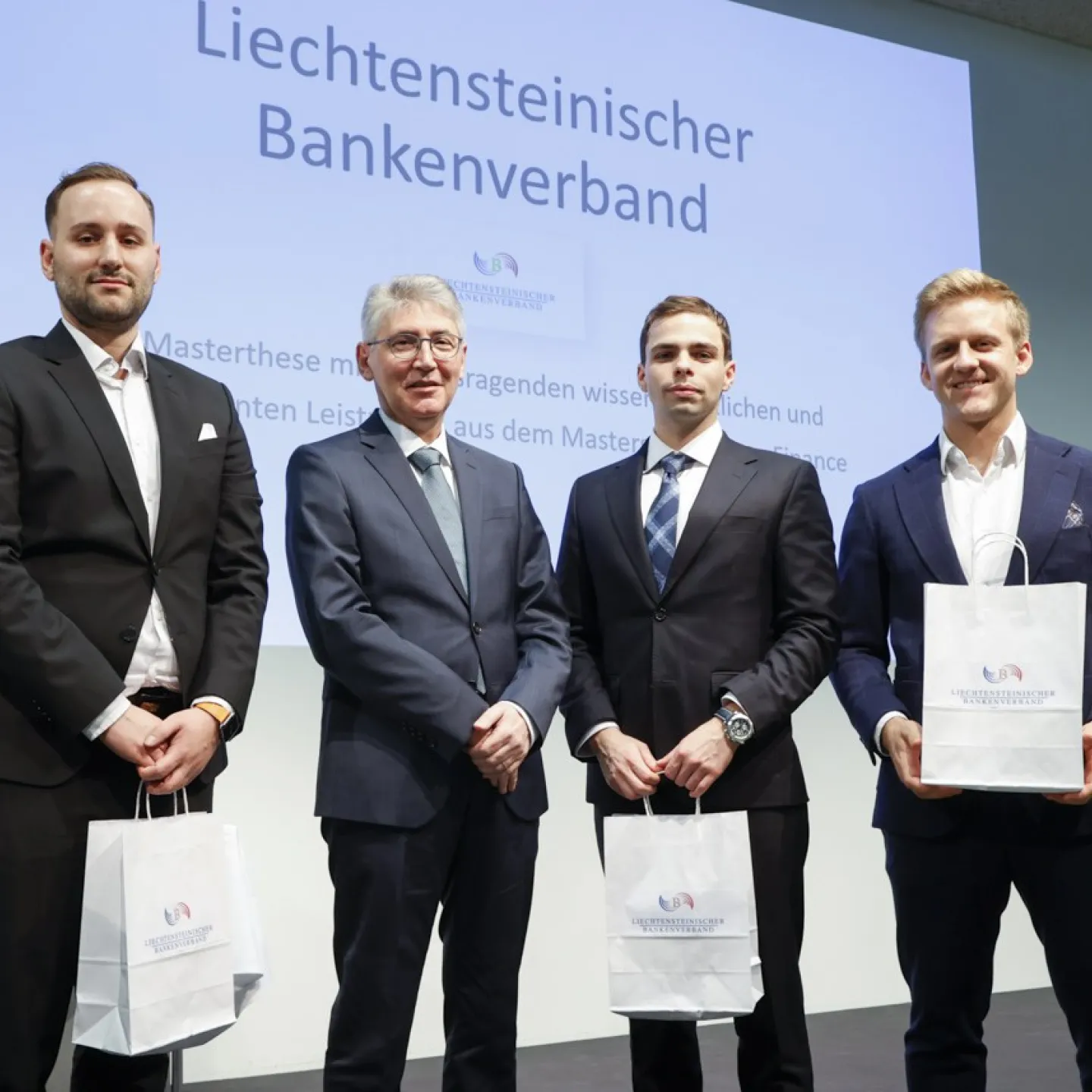 Dr. Hans-Werner Gassner zusammen mit Dario Sinnesberger, Tom Hermes und Nicolas Baumann, welche gerade ihr Diplom erhalten haben.