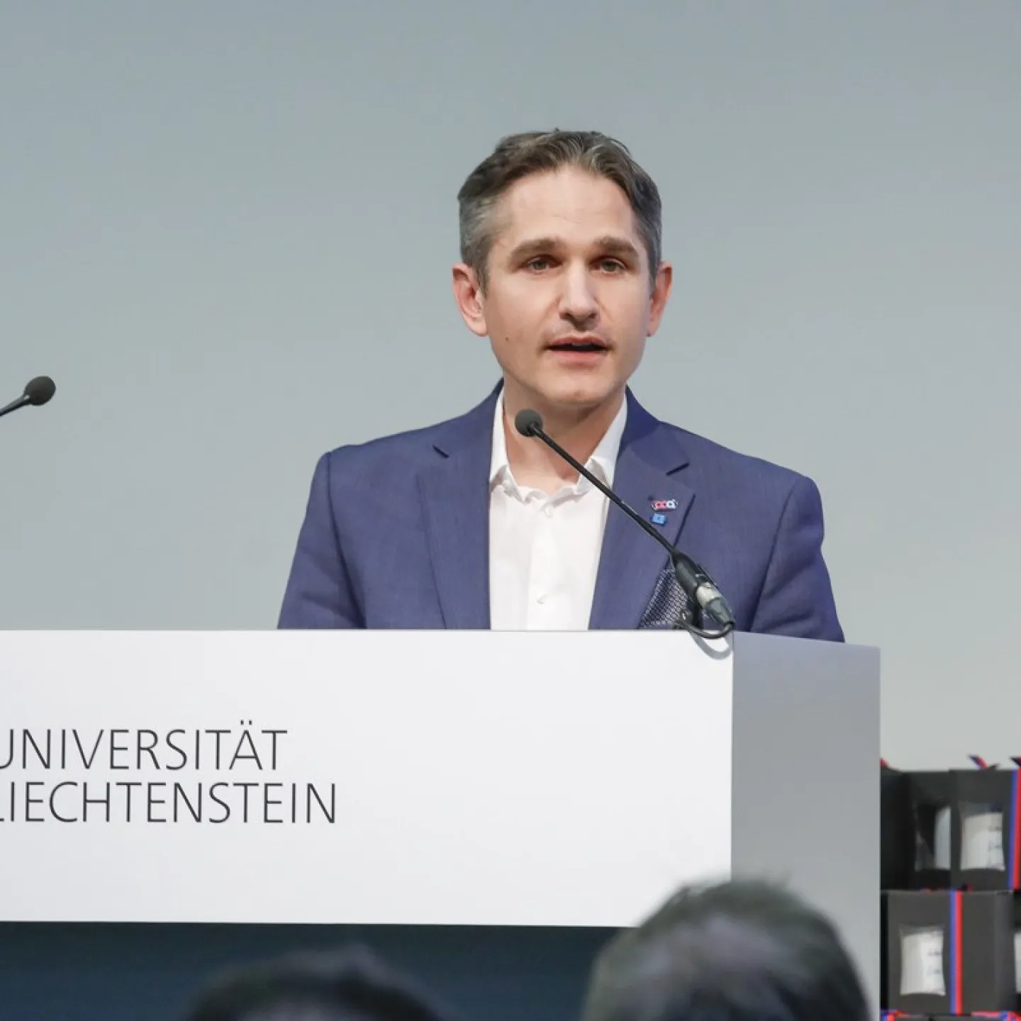 Dr. Thomas Nägele steht vor einem Rednerpult und hält eine Rede.