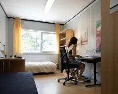 Studentin spielt Keyboard in ihrem Zimmer im Studierendenwohnheim der Universität Liechtenstein.