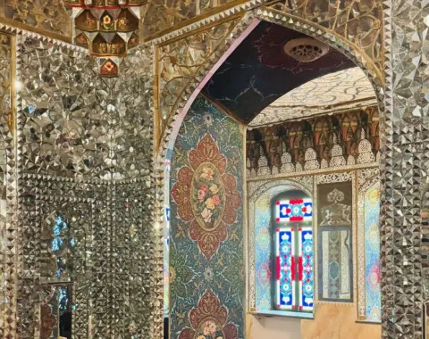 Prächtiger Innenraum mit reich verzierten Spiegelmosaiken und bunten Glasfenstern, die traditionelle georgische Architektur und Kunsthandwerk zeigen.