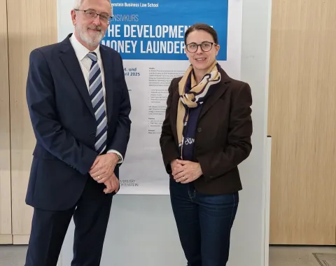 Zwei Personen stehen vor einem Poster des Intensivkurses „The Development of Money Laundering“ an der Universität Liechtenstein.