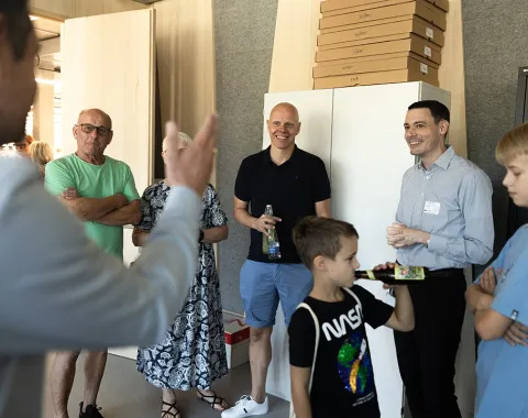 Gruppe von Menschen bei einer Führung im neuen Standort der Universität Liechtenstein, Ebaholz, während des Tags der offenen Tür. Ein Mann spricht zu den Besuchern, die aufmerksam zuhören.