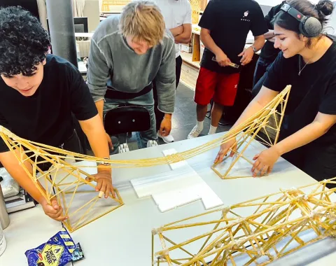 Studierende bauen eine Brücke aus Spaghettinudeln