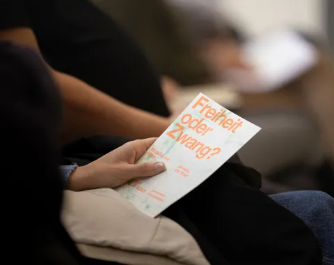 Flyer des Symposiums mit dem Titel "Freiheit oder Zwang."