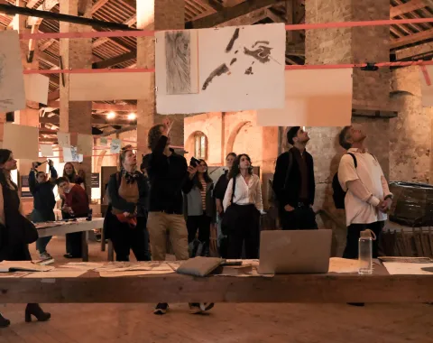 Bild in Brauntönen mit Menschen in einer Ausstellung