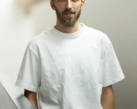 Foto eines jungen Mannes mit weissem T-Shirt und Bart