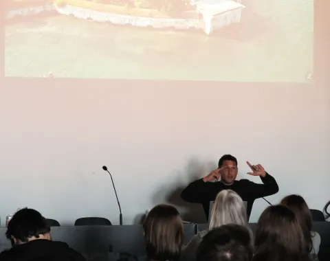 Mann präsentiert vor einer Leinwand