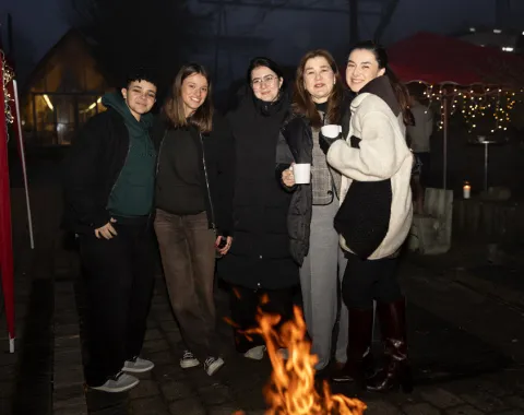 Studierende wärmen sich an der Feuerschale.