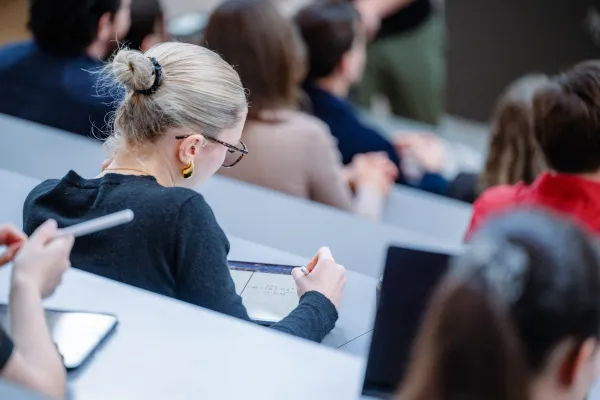 Eine Studentin macht sich digitale Notizen auf einem Tablet während einer Vorlesung an der Universität Liechtenstein.