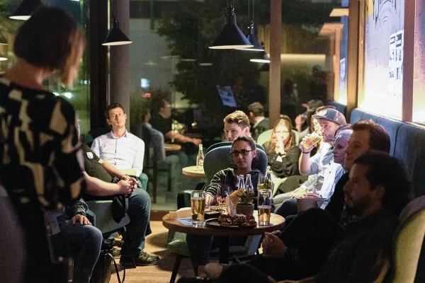 Studierende und Alumni bei informellem Networking Abend in gemütlicher Atmosphäre mit Getränken und Gesprächen