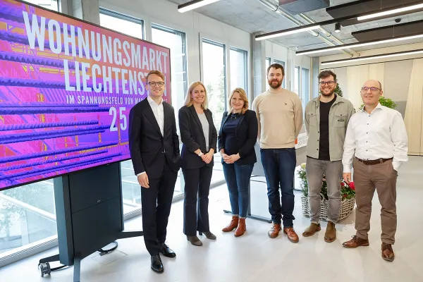 Gruppenfoto vor dem Plakat mit dem Titel "Wohnungsmarkt Liechtenstein"