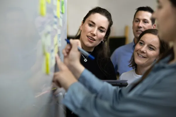 Interaktive Gruppenarbeit mit Post-its an einem Whiteboard im Seminarraum der Universität Liechtenstein.