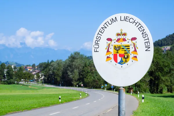 Grenzschild Fuerstentum Liechtenstein Strasse in grüner Umgebung