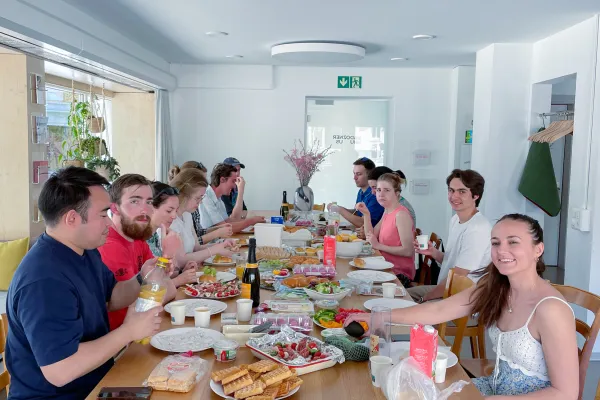 Internationale Studierende sitzen um einen Tisch beim Essen