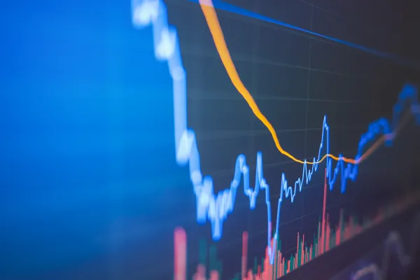 Finanzdiagramm mit blauer und orangefarbener Linie auf Bildschirm.