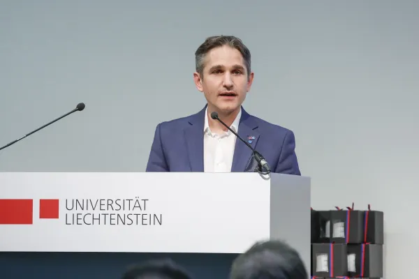 Dr. Thomas Nägele steht vor einem Rednerpult und hält eine Rede.