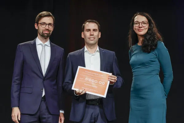 PD Dr. Bernhard Burtscher, Alois Wille und Dr. Christina Preiner mit einem Preis auf dem 5000 CHF steht.